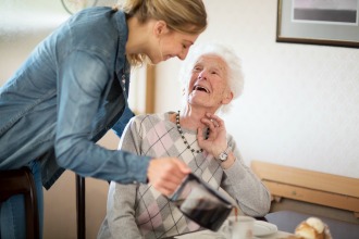 Jüngere Frau kümmert sich um ältere Frau